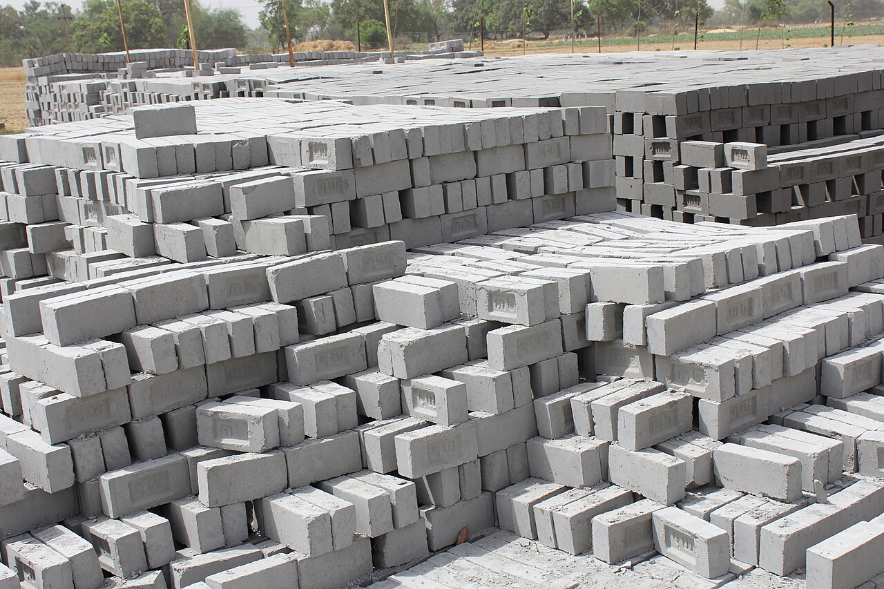 Vast stacks of grey cement bricks in a production yard